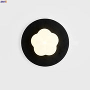 Modern black travertine wall lights with textured circular sconce and glowing four-petal flower led center by decorbites