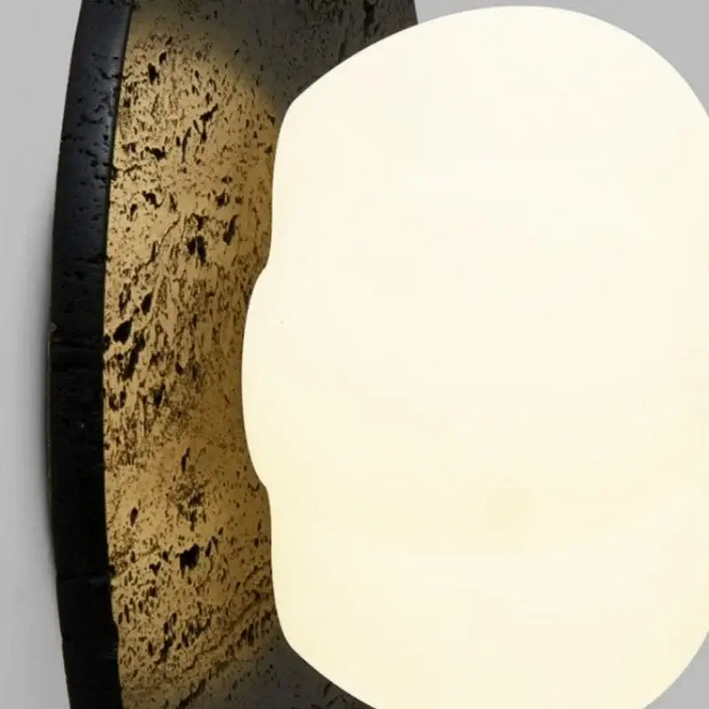 Modern black travertine bedroom wall lights with matte black frame textured cork backplate and oval frosted diffuser