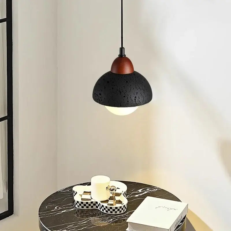 Modern black travertine pendant light with textured black finish and warm wood toned top for bedroom decorbites black travertine
