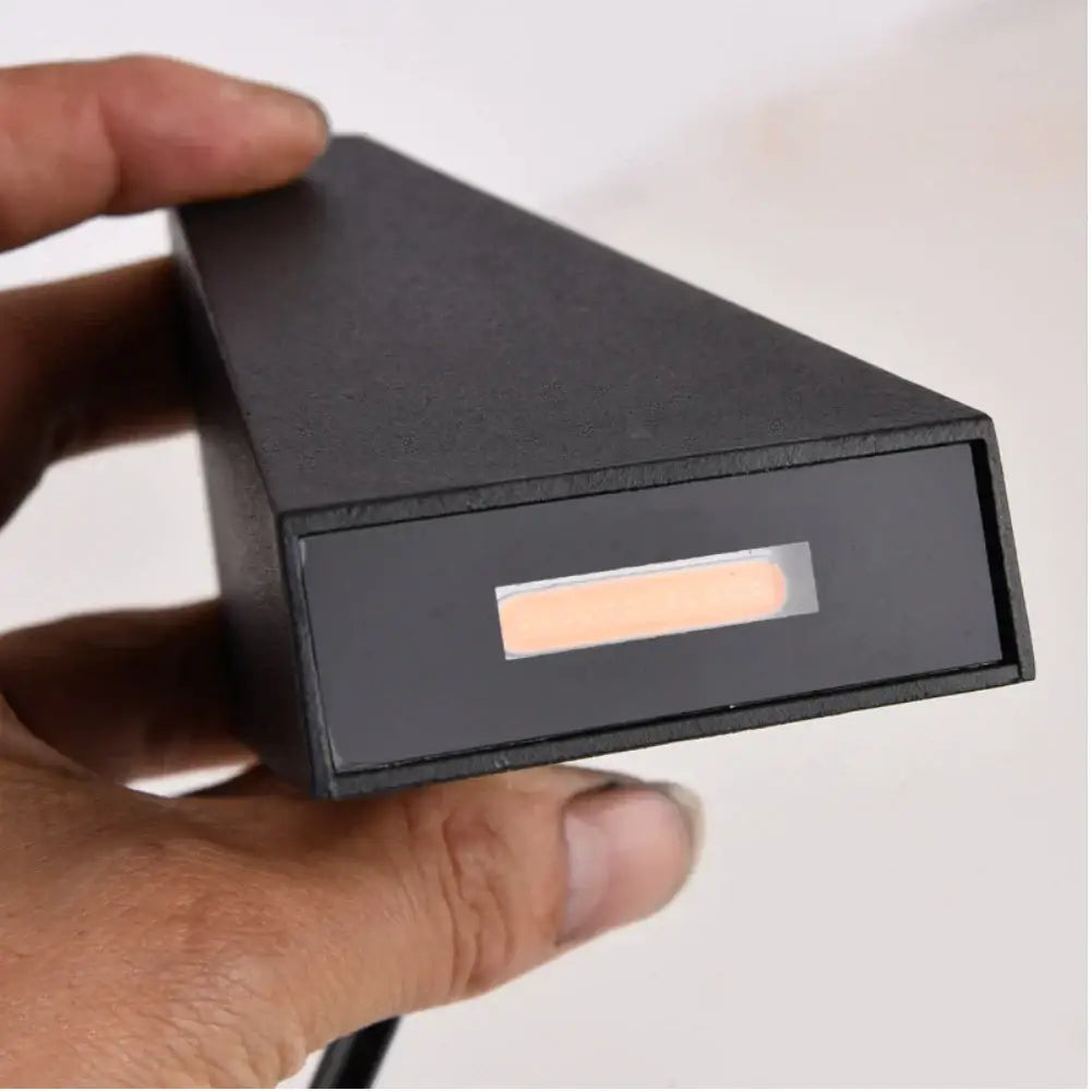 Modern black triangular led wall light featuring a matte finish and an illuminated orange strip for decorbites led wall use