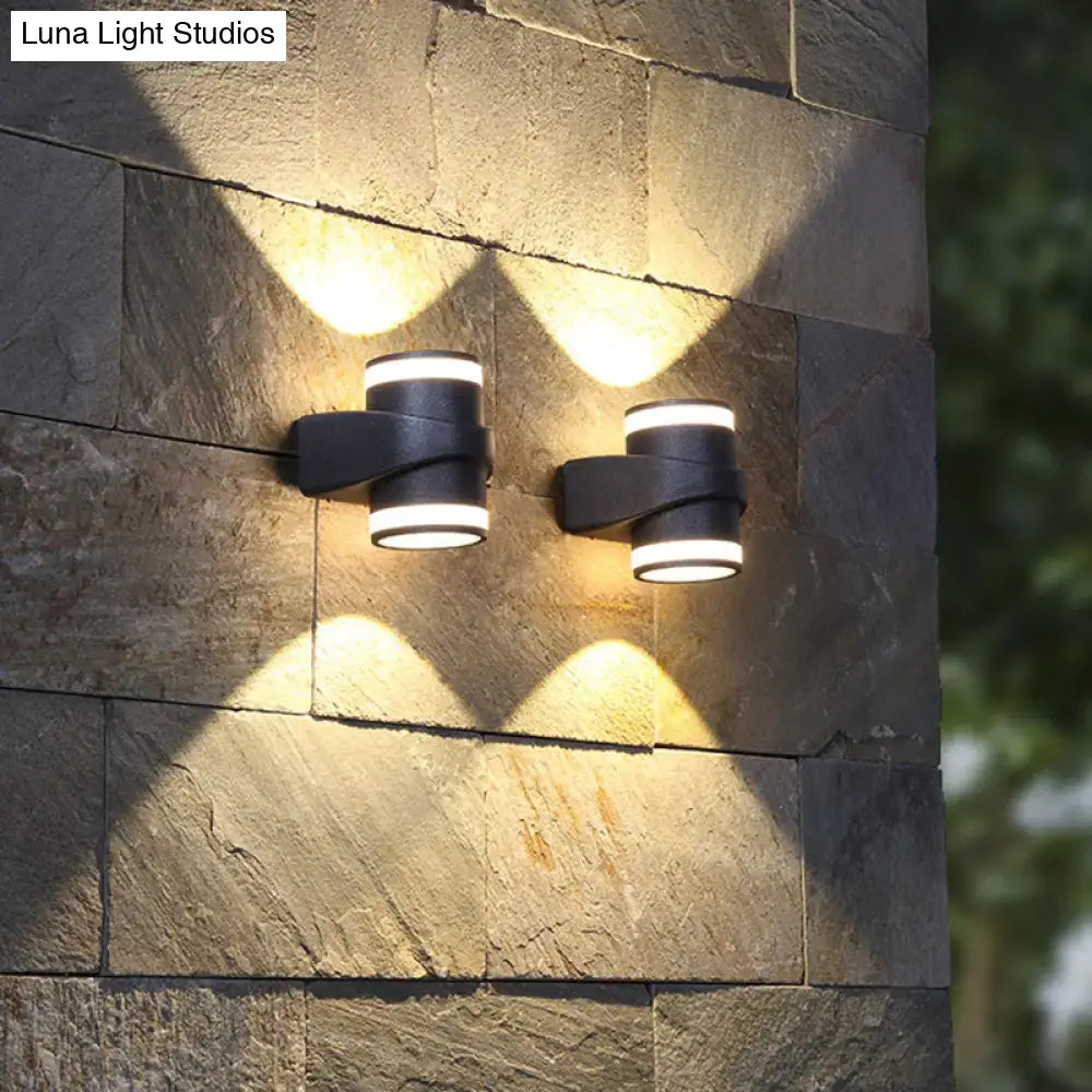 Modern black tubular metal wall washer sconce with white led rings emitting warm light for outdoor use