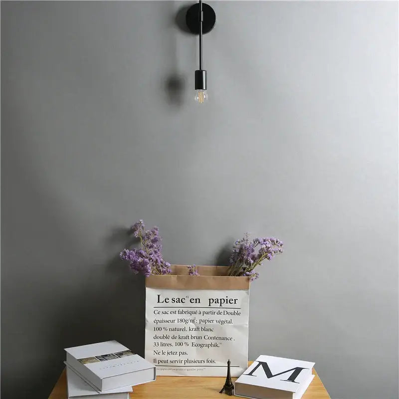Modern black two arm led wall lamp with slender stem and exposed filament bulb for bedroom vanity lighting