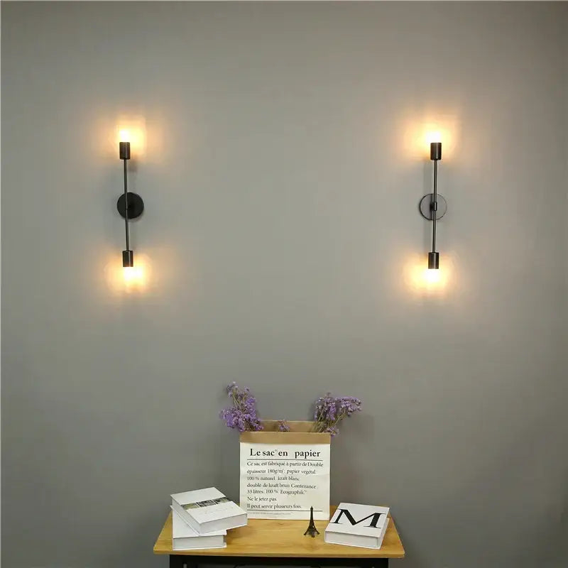 Pair of modern black led wall lamps with cylindrical shades and circular backplates for bedroom vanity lighting