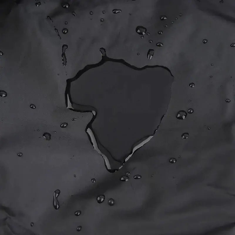 Modern black waterproof bbq grill cover made of dark gray water-resistant fabric with condensation beads visible