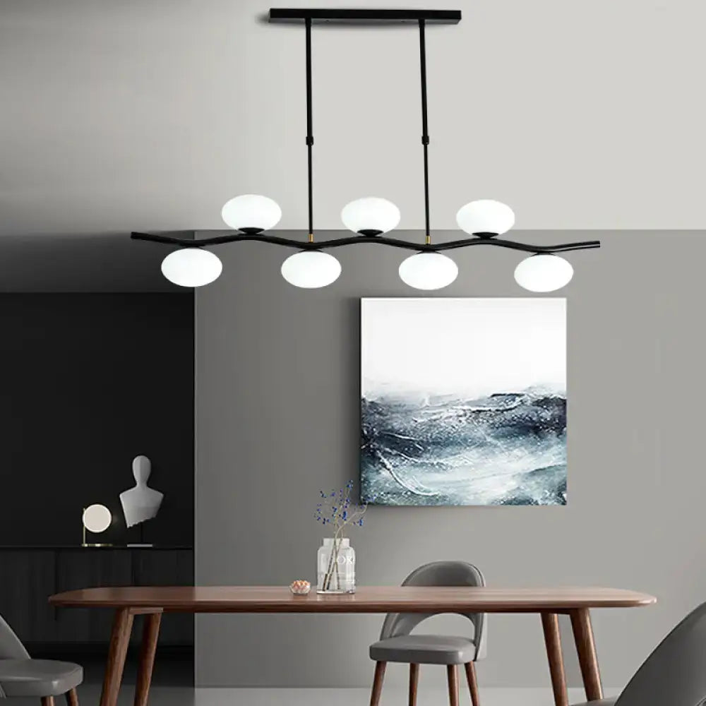 Modern black wavy pendant light with six frosted white glass globes for ceiling island lighting by DecorBites