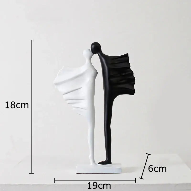 Modern black and white abstract lovers resin sculpture features two embracing figures with flowing forms on a rectangular base
