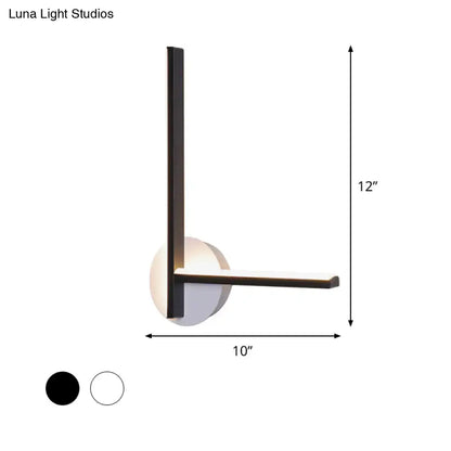 Modern black and white acrylic cross wall sconce with sleek metal frame and warm white circular diffuser for bedroom use