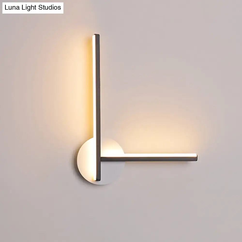 Modern minimalist l-shaped acrylic cross wall sconce with sleek metallic arms and warm white light for bedroom use