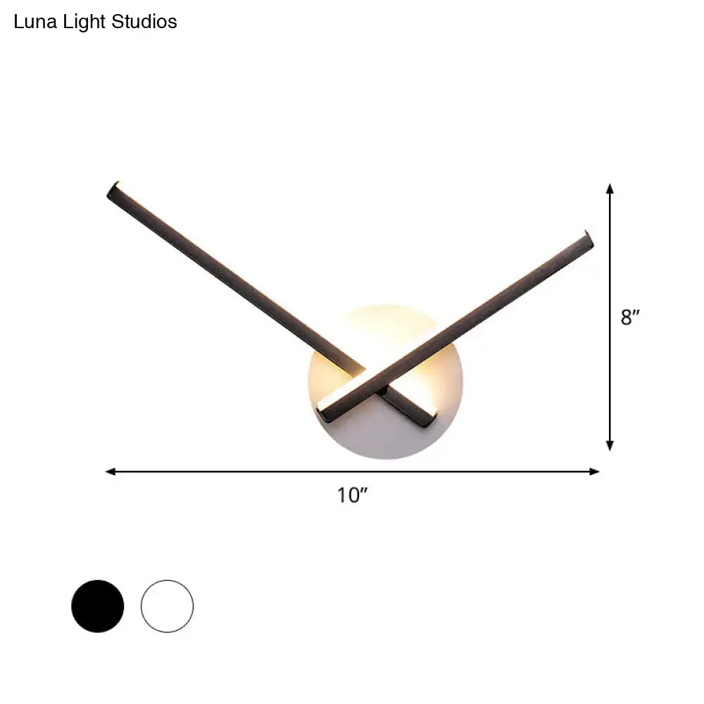 Modern black and white acrylic cross wall sconce with two intersecting arms emitting warm white light for bedroom use