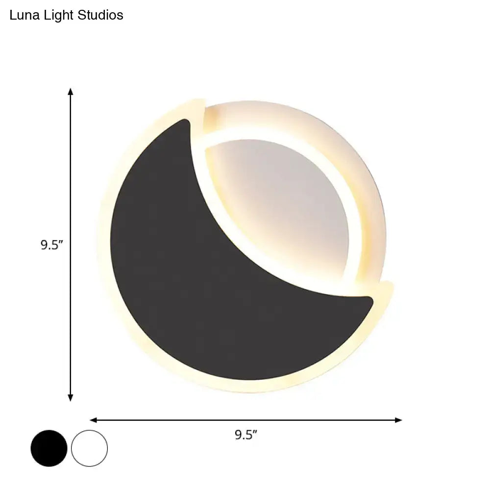 Modern black and white acrylic wall sconce with sleek crescent design and warm illuminated led ring for bedroom lighting