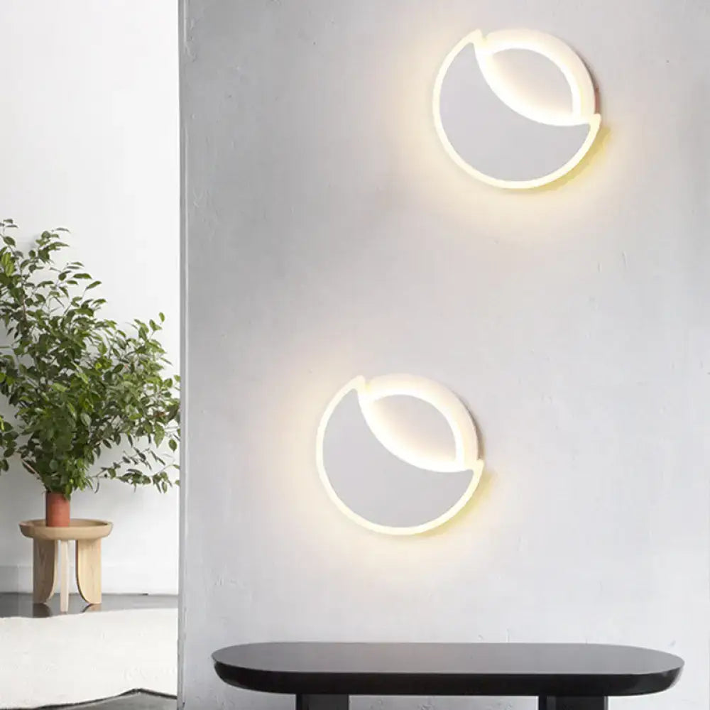 Modern black and white acrylic eclipse wall sconce with sleek circular design and soft white led bedroom lighting