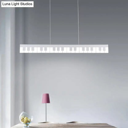 A sleek white acrylic piano key chandelier lamp fixture with minimalist design hangs from thin cords for modern decor