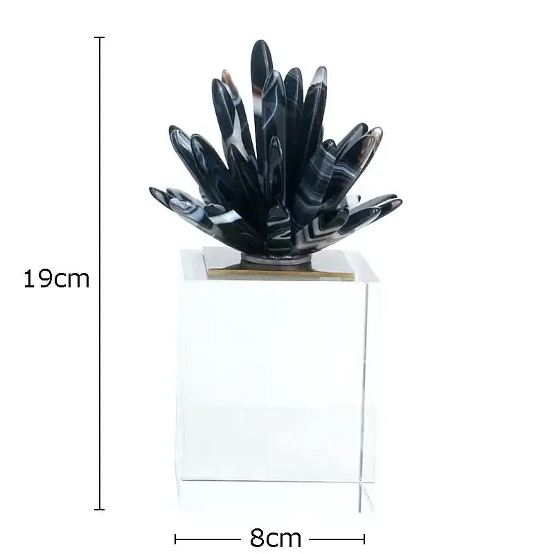 Modern black and white crystal art featuring a glossy black agate flower sculpture on a clear acrylic base