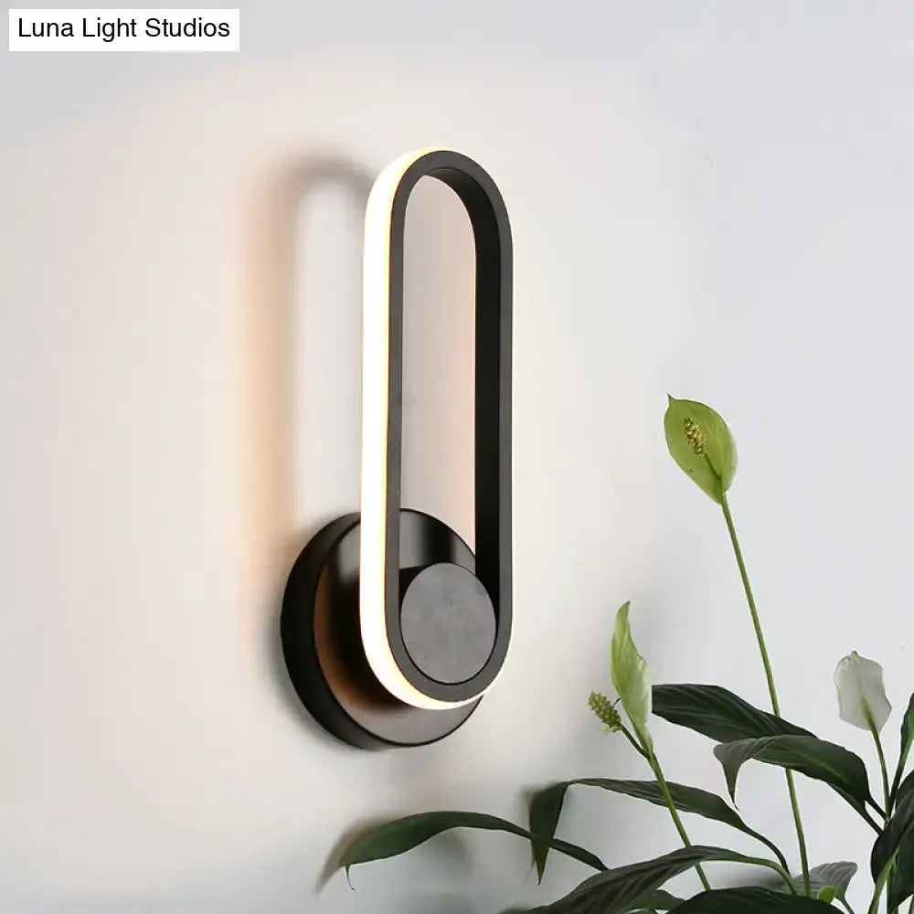 Modern black and white aluminum frame wall lamp with minimalist design emitting warm white light for bedroom use
