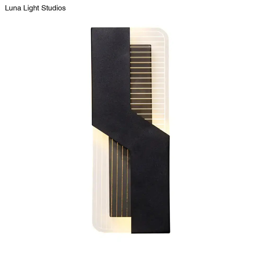 Modern black and white angular led wall mount light with vertical slats emitting warm light for bedroom use
