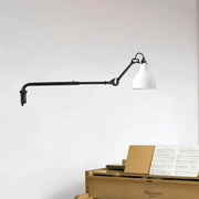 Modern black and white articulated bedroom wall lamp with direct wired electric power source and conical shade
