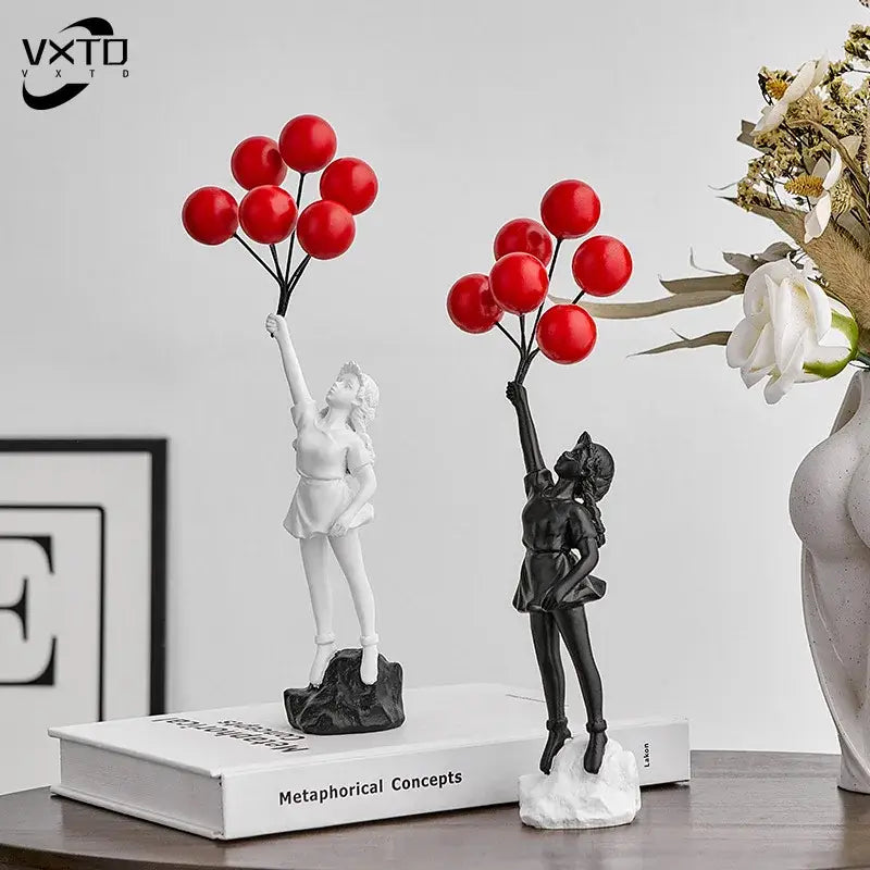 Two resin balloon girl graffiti statues in black and white holding red balloons for modern living room decor