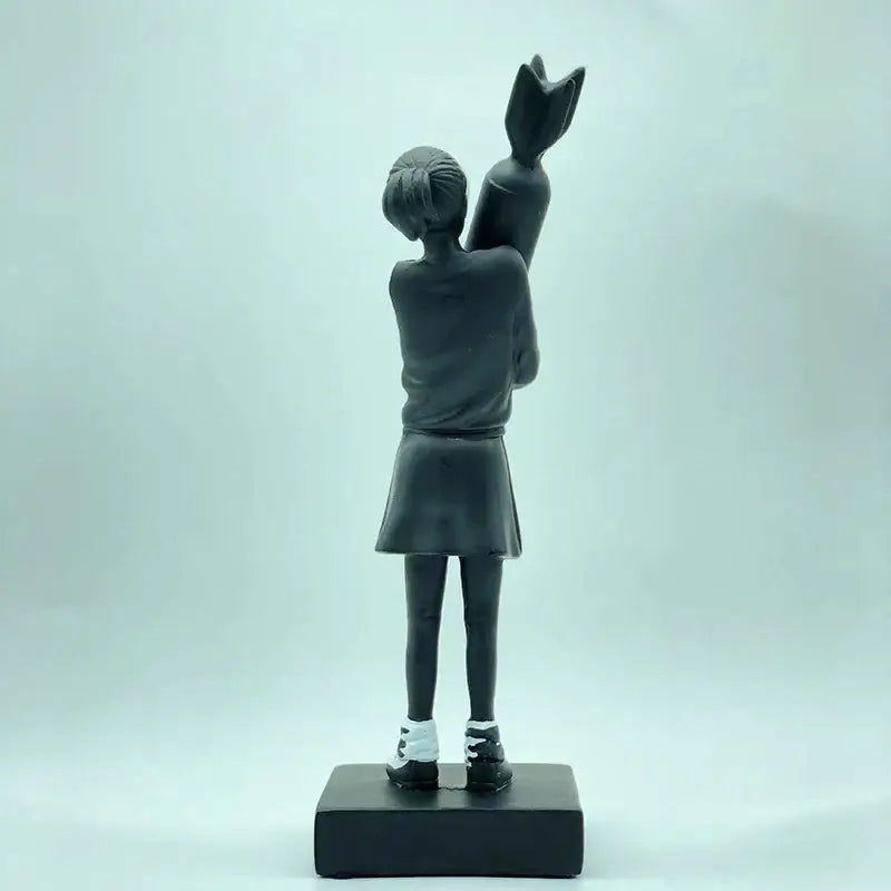 Modern black and white bomb hugger girl resin statue featuring a black resin hugger girl holding oversized candy cane decorbites bomb hugger