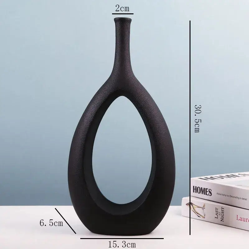 Modern black decorbites ceramic vase with sleek teardrop shape and open center for living room decor