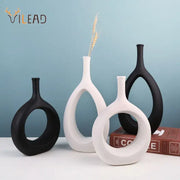 Set of three modern black and white ceramic vases with sleek curved designs and circular cutouts for living room decorbites ceramic vase