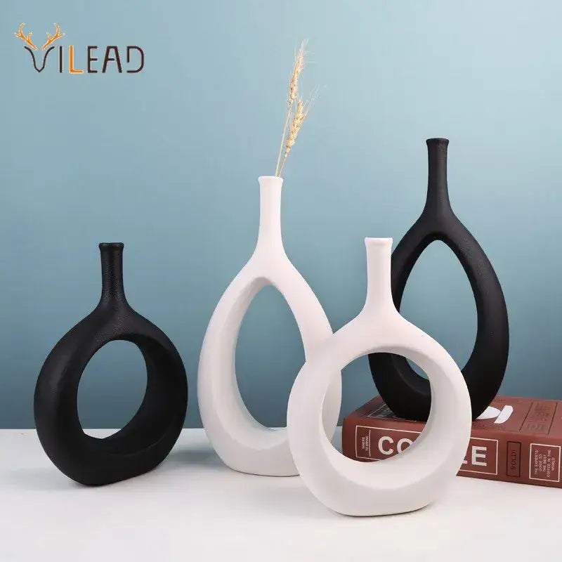 Set of three modern black and white ceramic vases with sleek curved designs and circular cutouts for living room decorbites ceramic vase