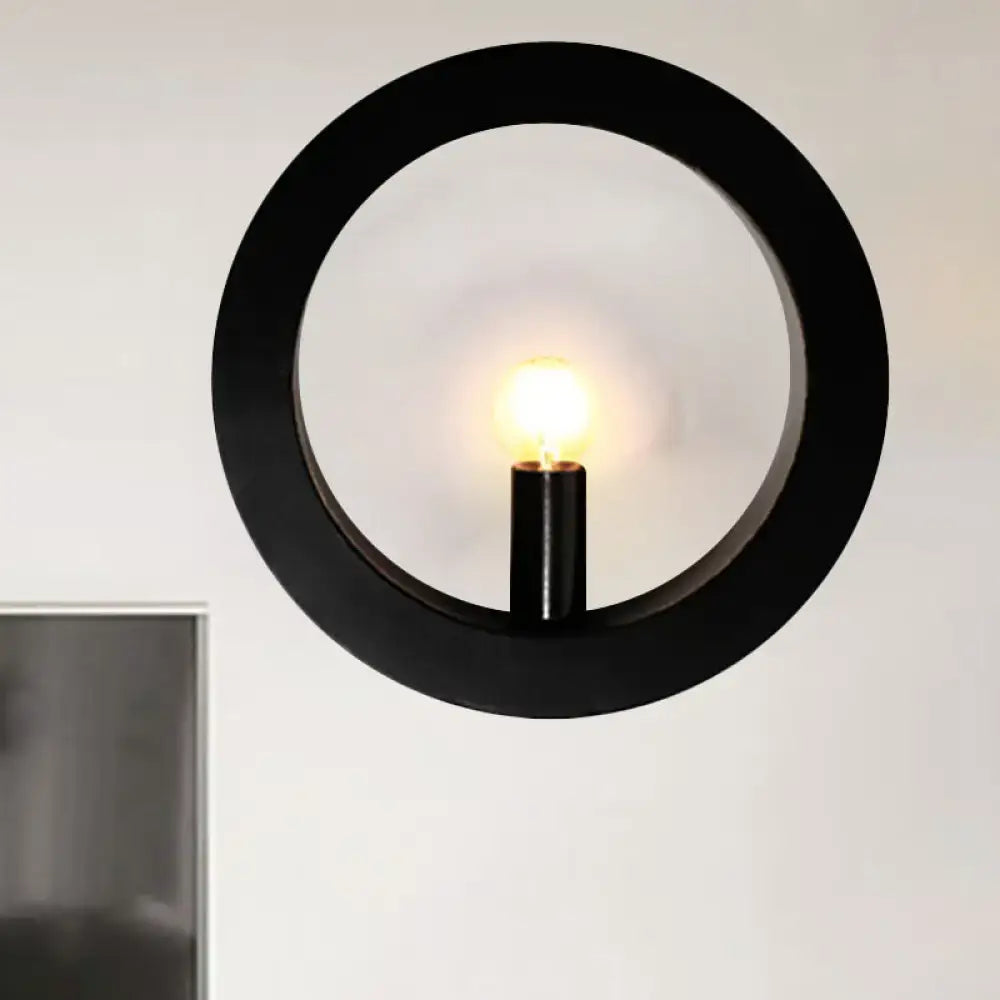 Modern black and white circle wall light featuring a black circular wall lamp with a central illuminated bulb for bedrooms