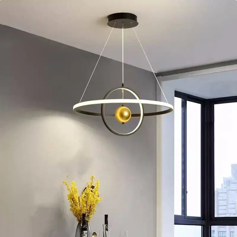 Modern black and white circular iron ball pendant light with matte black rings and a central golden sphere for living room decorbites circular iron