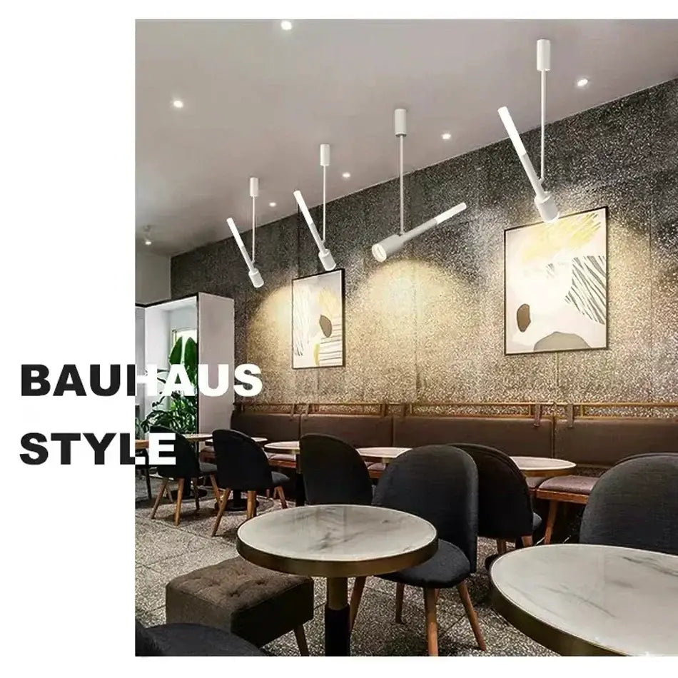 Modern black and white cob pendant spotlight with sleek metallic fixtures hanging in a bauhaus-style café living room light