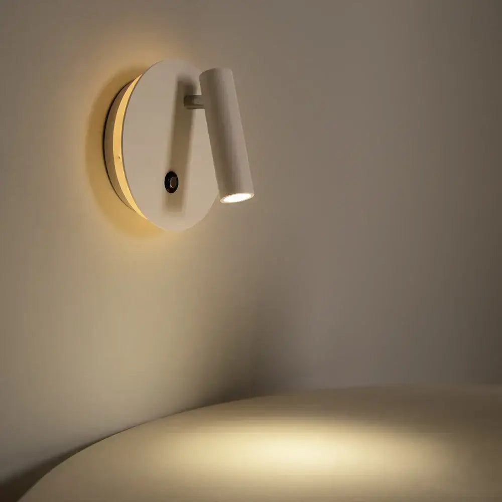Modern black and white dimmable led wall lamp with a sleek cylindrical head and warm ambient glow for bedroom reading by decorbites