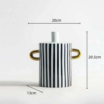 A sleek ceramic vase with bold black and white dots geometric stripes and shiny gold handles for living room decor