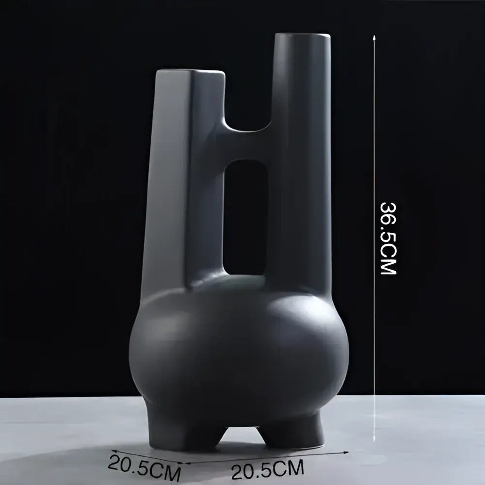 Black ceramic vase with rounded base, three legs, and tall handles with cutouts in elegant striped ceramic decorbites style