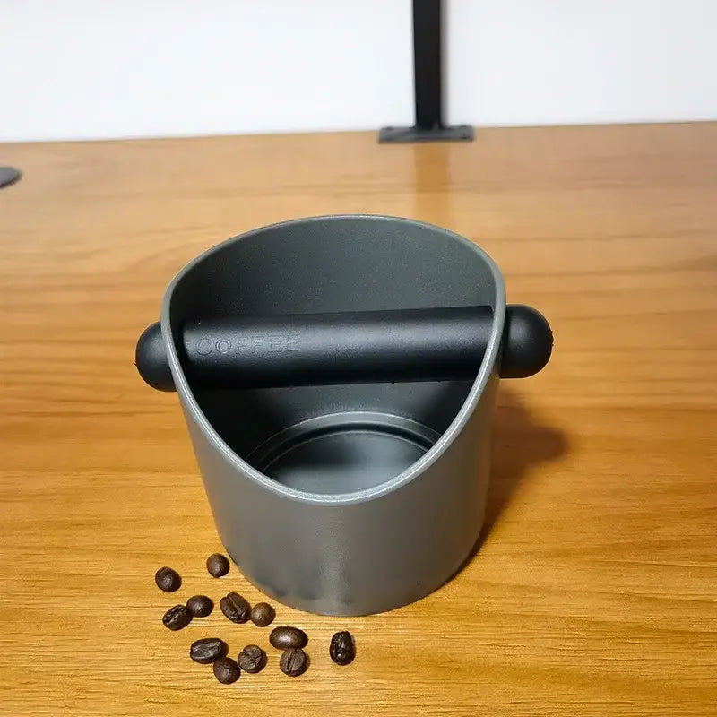 Modern black and white espresso knock box with gray coffee scoop featuring black handle and sleek matte finish decorbites espresso knock
