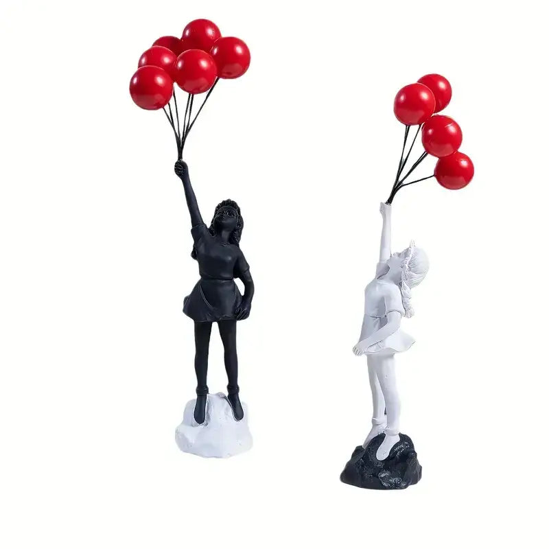 Two resin figurines black and white flying love balloon girls holding red balloons on rocky base for decorbites decor