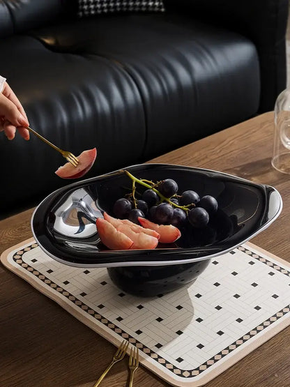 Modern black ceramic fruit bowl with sleek silver rim complementing decorbites geometric acrylic fruit plate design