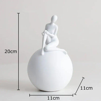 White ceramic figurine of a seated humanoid figure on a black and white geometric base character sculpture for decorbites geometric base decor