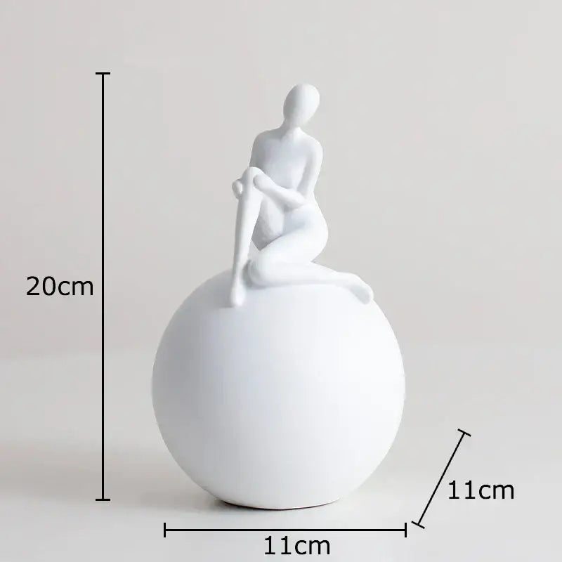 White ceramic figurine of a seated humanoid figure on a black and white geometric base character sculpture for decorbites geometric base decor