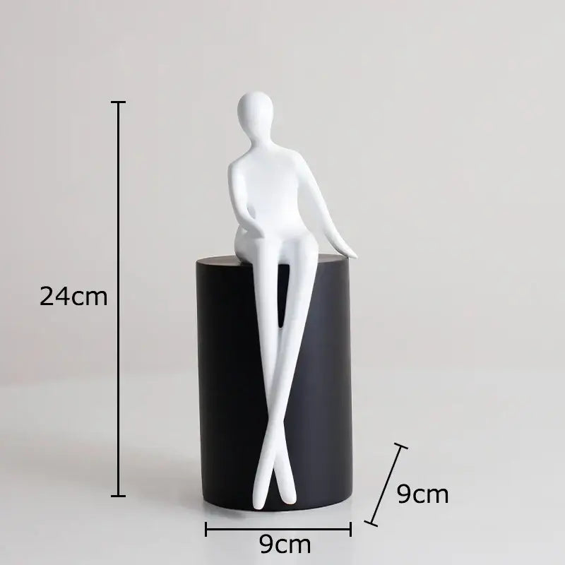 White minimalist seated human figurine with smooth glossy surface on black and white geometric base decorbites geometric base