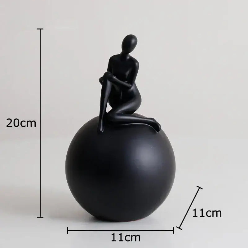 Modern black matte figurine seated on a decorbites geometric base character statue for living room decor