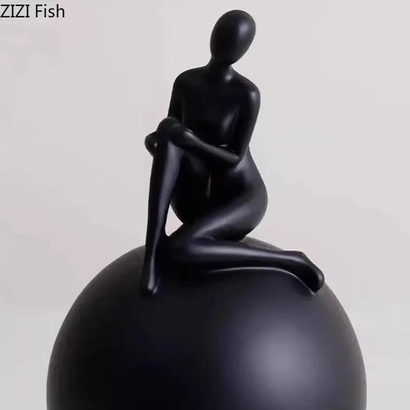 Black glossy resin sculpture of a seated figure with a geometric base decorbites geometric base character for living room decor