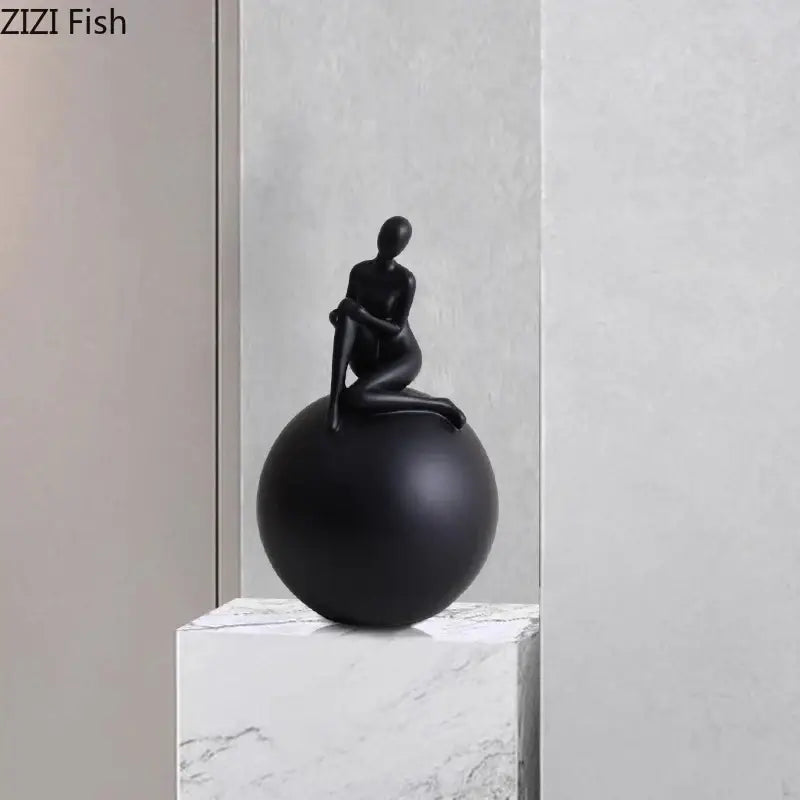 Modern black matte figurine of a seated human form on a geometric base character decorbites geometric base decor