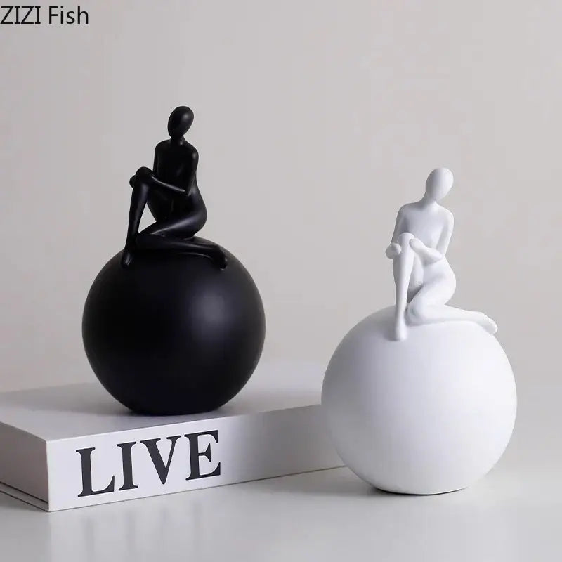 Modern black and white abstract human figurines seated on smooth geometric base character statues for living room decorbites geometric base decor