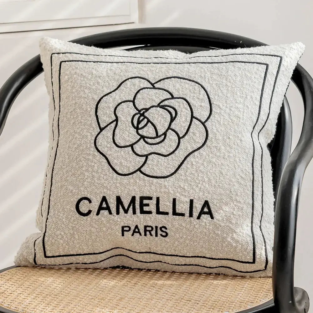Beige textured cushion cover with black embroidered camellia flower and camellia paris text by decorbites geometric jacquard