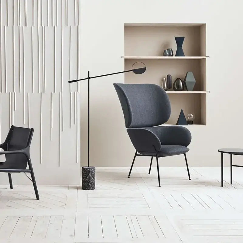 Dark gray upholstered armchair with sleek black metal legs paired with modern black and white geometric line pendant lamp for dining room decorbites geometric line