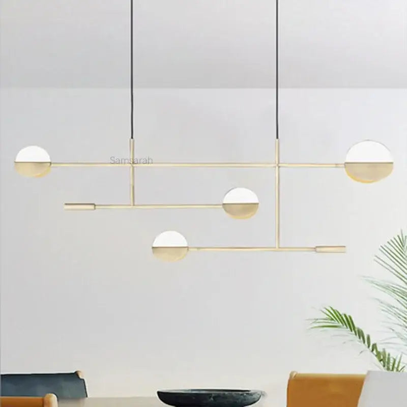 Modern black and white geometric line pendant lamp with gold-toned spherical glass shades for dining room decorbites geometric line