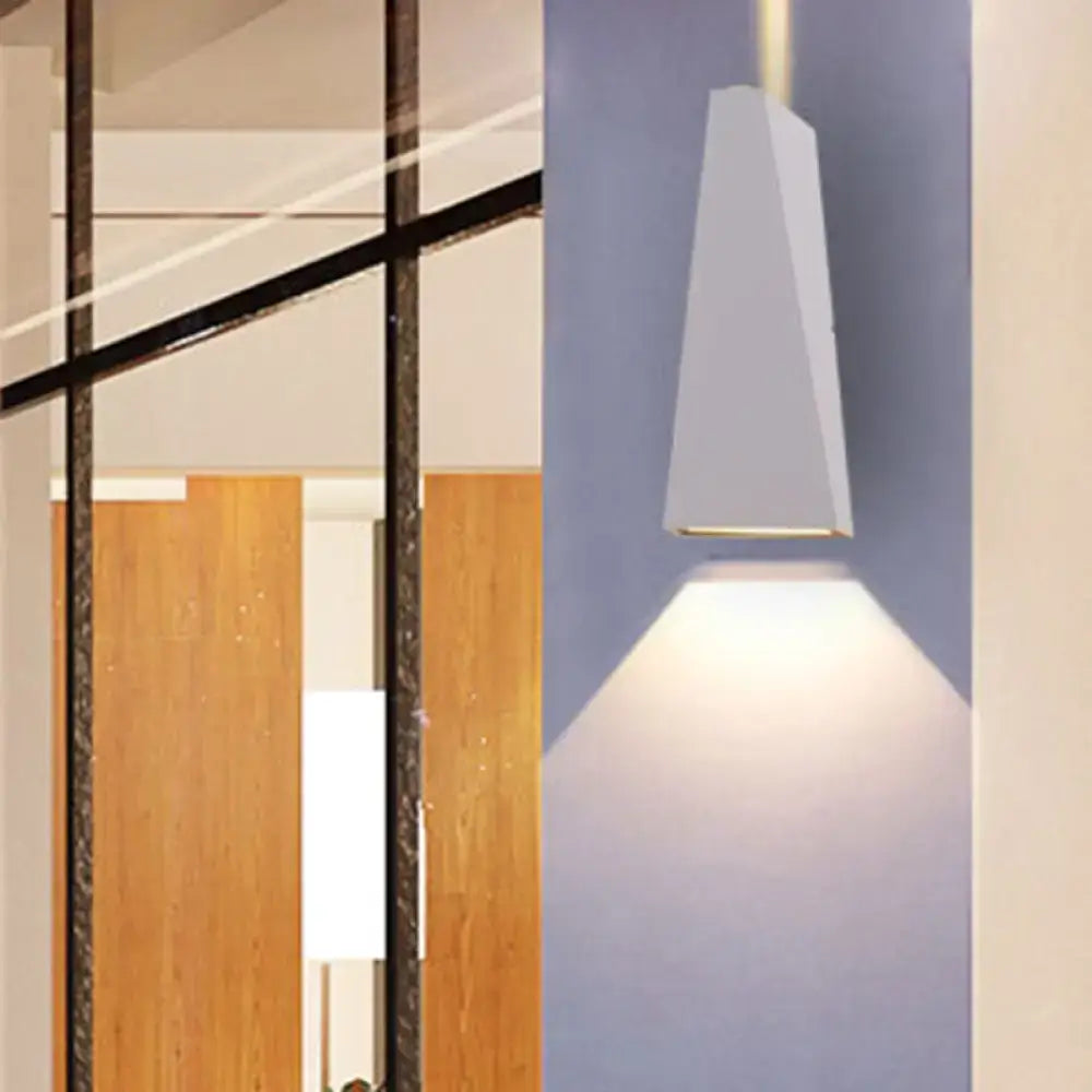 Modern black and white nord wall sconce with a sleek geometric design casting focused light downward as a wall lamp
