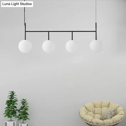 Modern black metal pendant light fixture featuring four frosted white glass orbs ideal for contemporary spaces