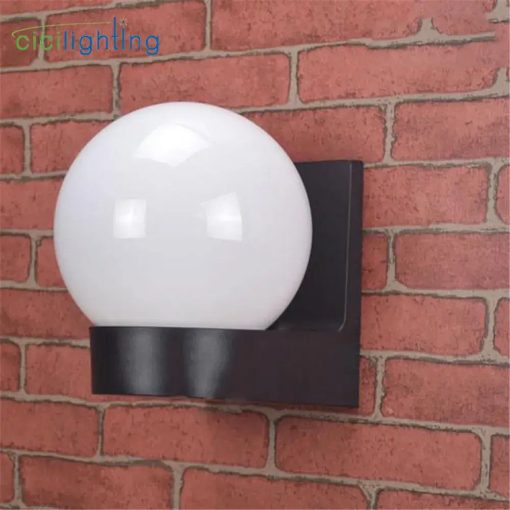 Modern black and white globe wall lamp with glass globe and metal bracket designed as outdoor porch light