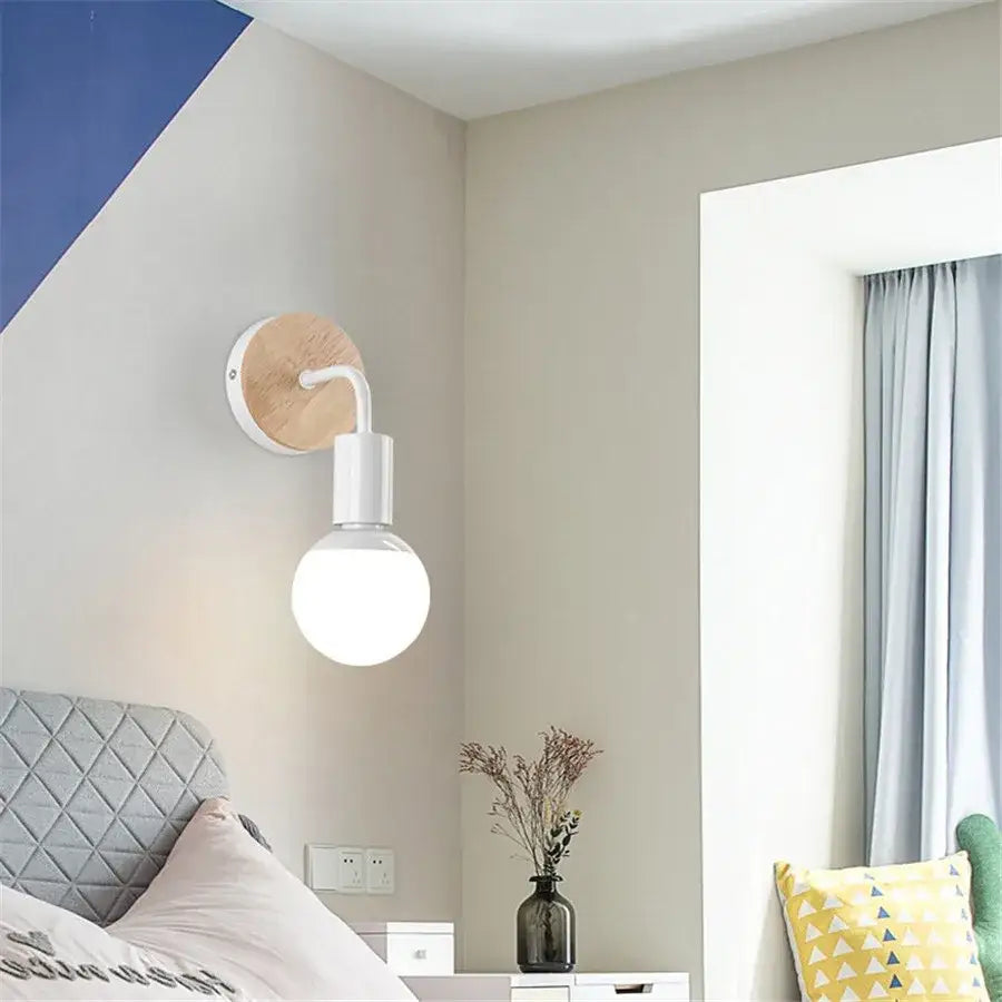 Modern black and white iron art wall light with round wooden backplate and exposed bulb for bedroom decorbites iron art