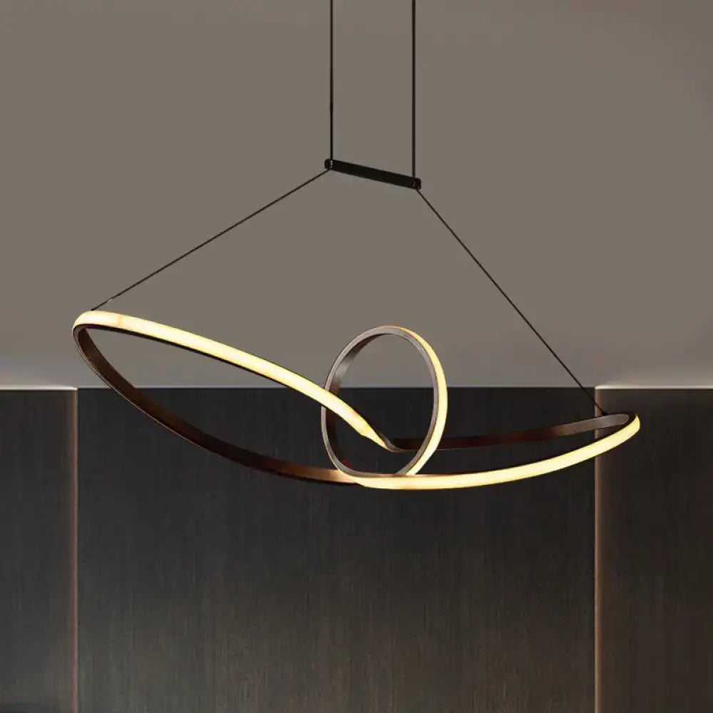 Modern minimalist metal knotting island pendant with two interlocking rings in matte black and warm gold glow