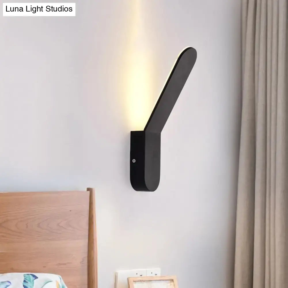Modern black and white oval shape corridor wall sconce with sleek angular design and warm led lighting